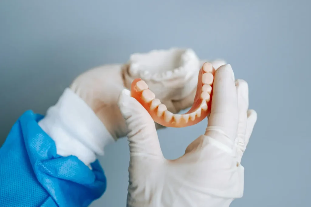 Tandlæge justerer tandprotesen for perfekt pasform